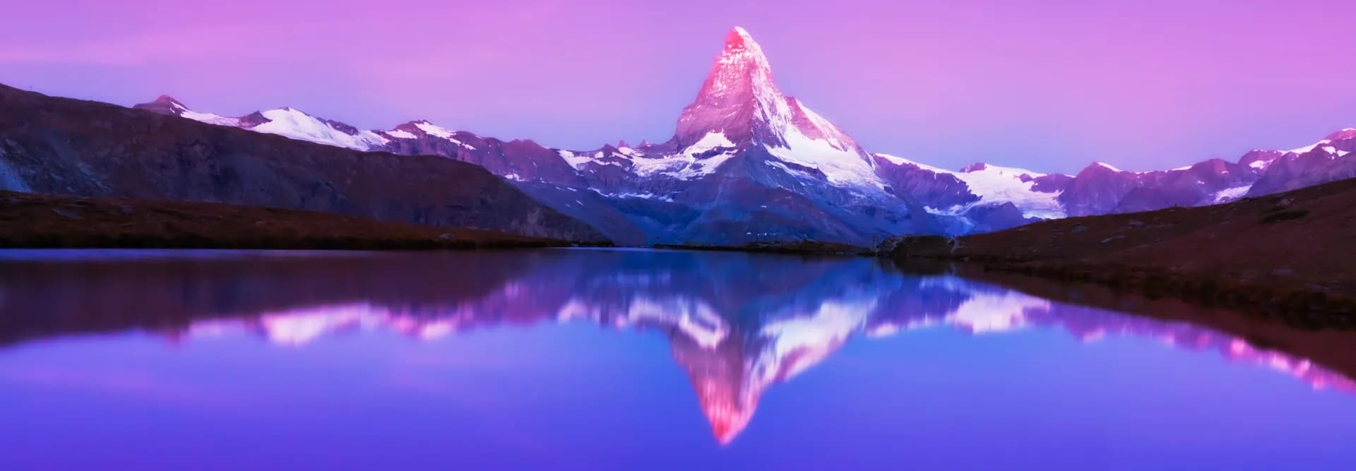 Matterhorn reflected in a glacier lake at sunset